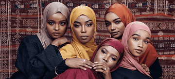 Women wearing colorful hijabs and modest fashion posing together indoors