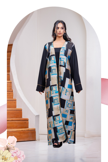 Woman wearing a modern abaya with geometric gold, black and blue pattern, modest fashion