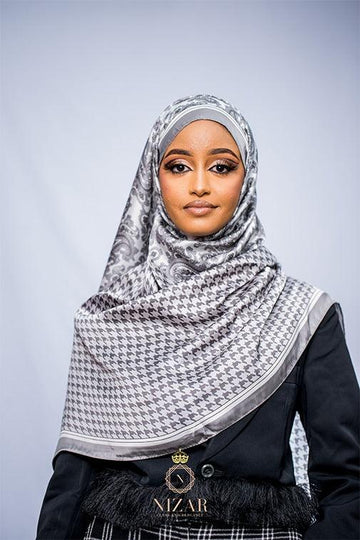 Woman in elegant patterned hijab and black coat, modest fashion, neutral background